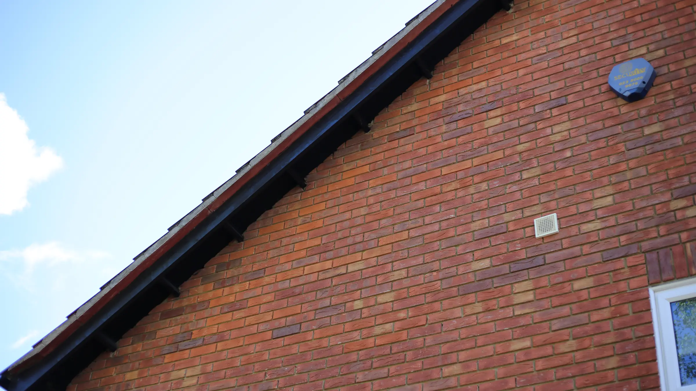 A pitched roof and roofline on a West London house against a clear sky