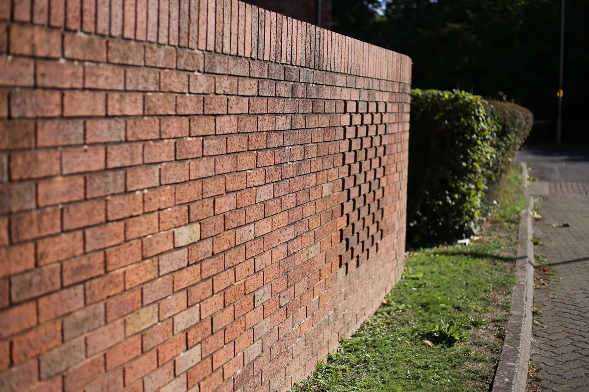 A brick wall with a decorative pierced panel
