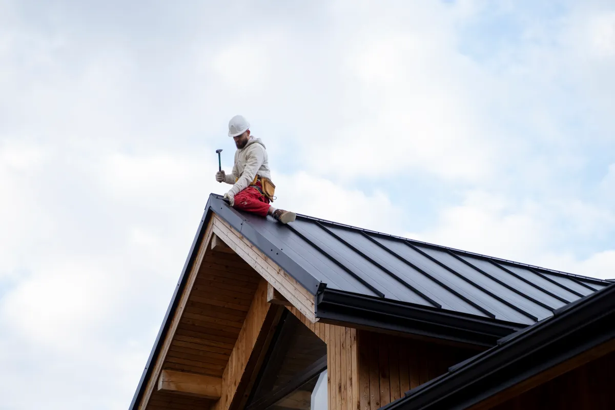 A standing seam metal roof being installed on a commercial unit