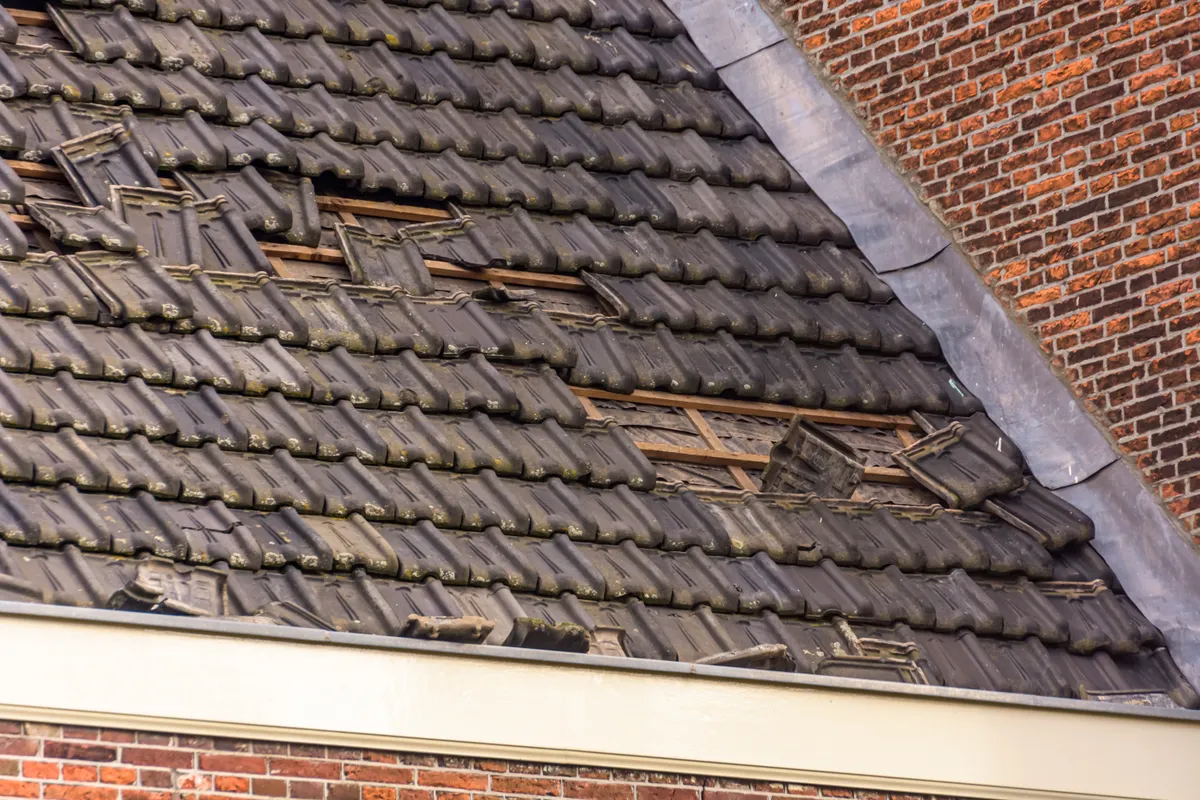 A roof stripped back to the battens after storm damage