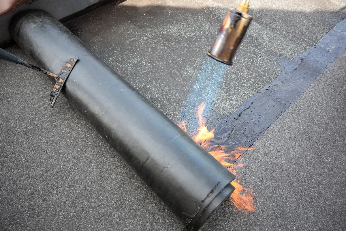 Torch on felt being bonded to a flat roof deck