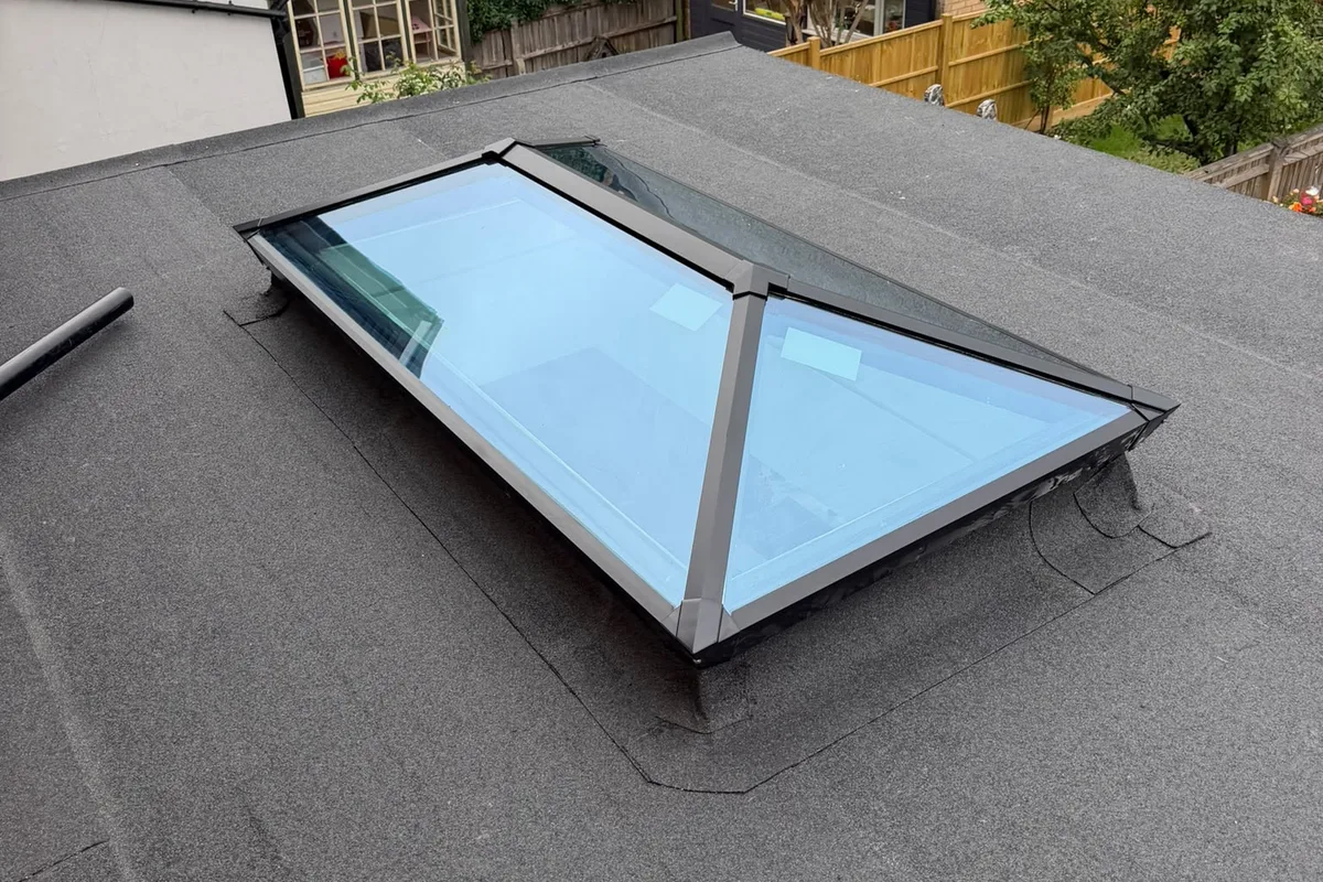 A finished felt flat roof with a glass lantern rooflight set into it