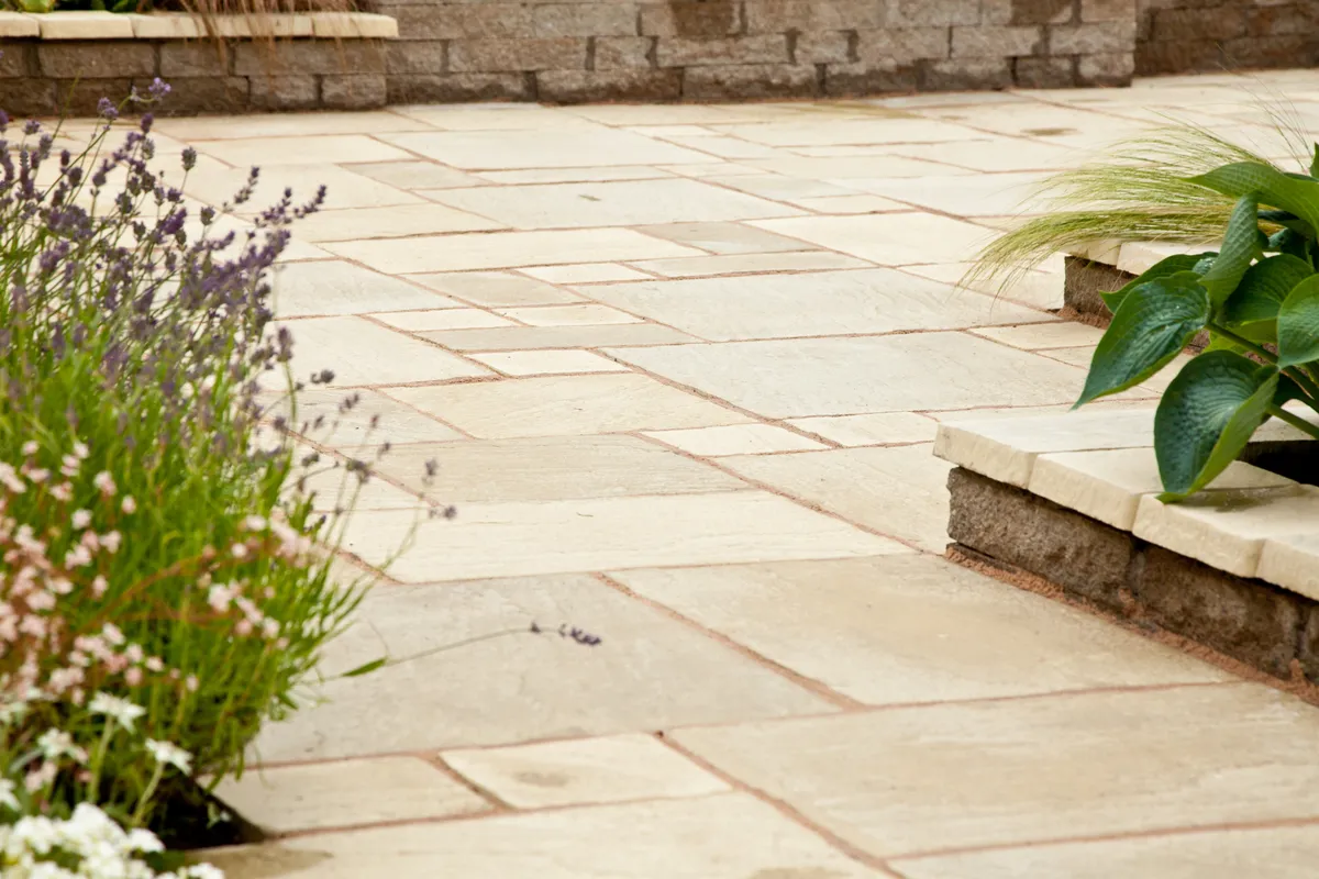 Sandstone paving laid around a planted border