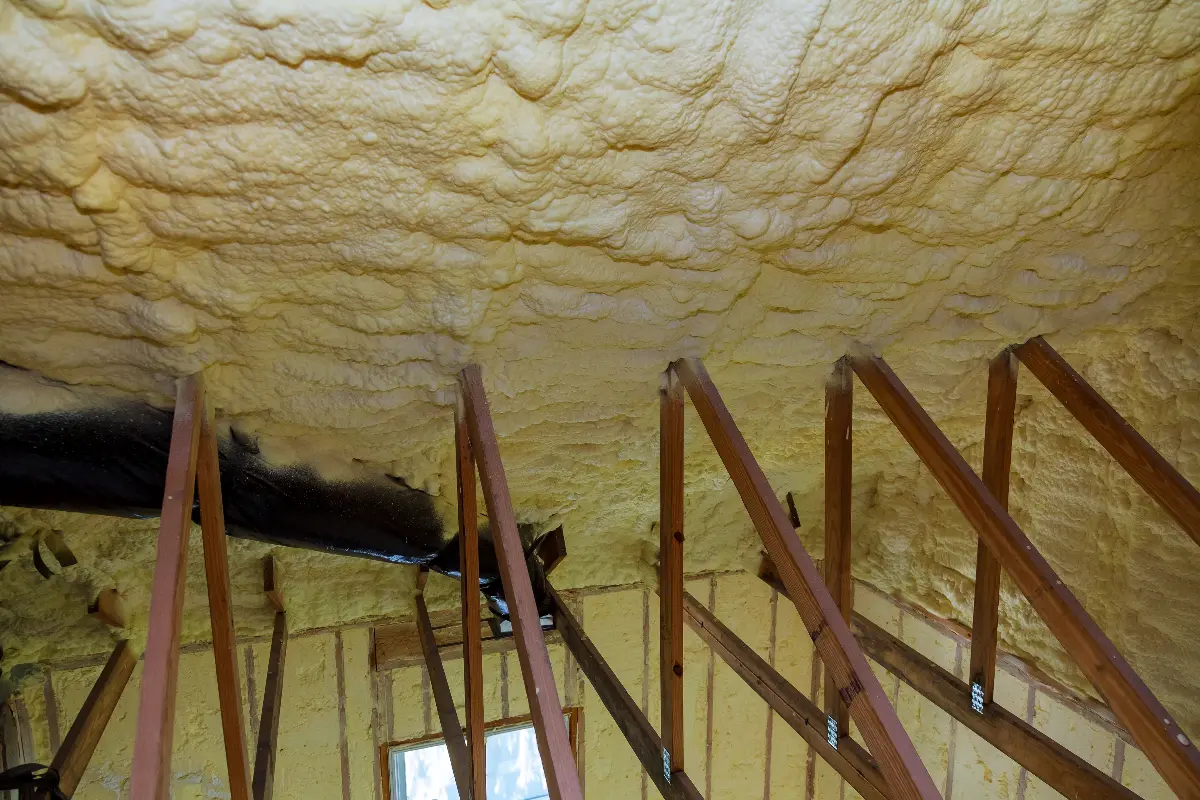 Spray foam insulation on the underside of a roof being removed