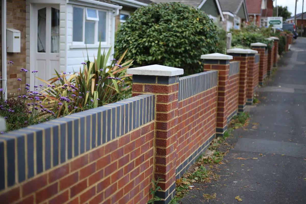 A brick garden wall with brick-on-edge coping